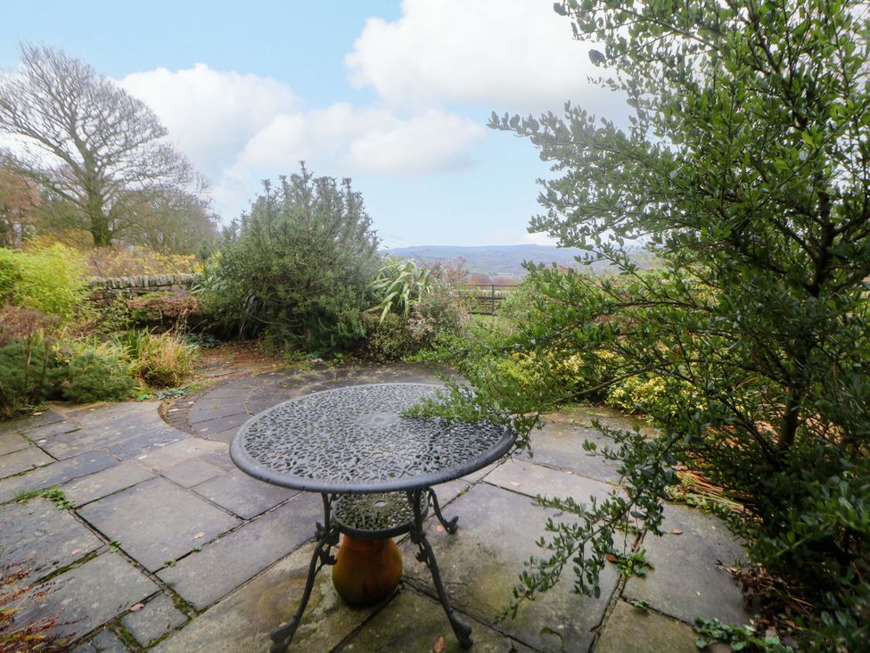A garden with a table and greenery at The Farmhouse in High Peak