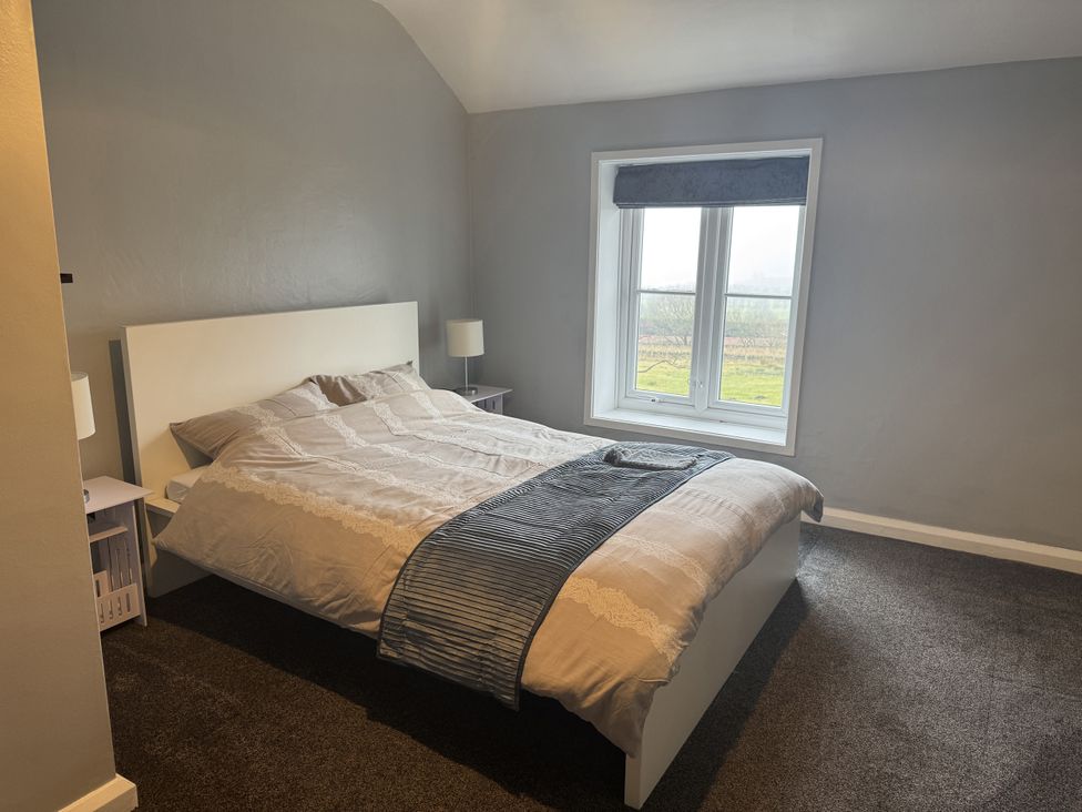 A bedroom with a bed and bedside tables at The Farmhouse in High Peak