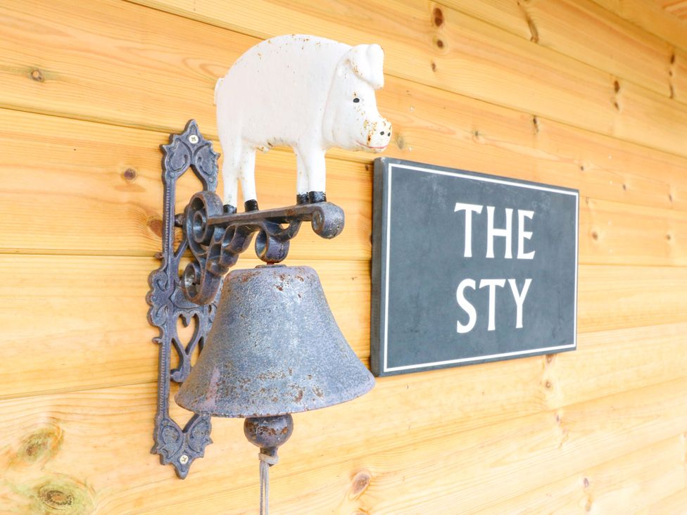 A wall with a pig bell and sign at The Sty in Derby