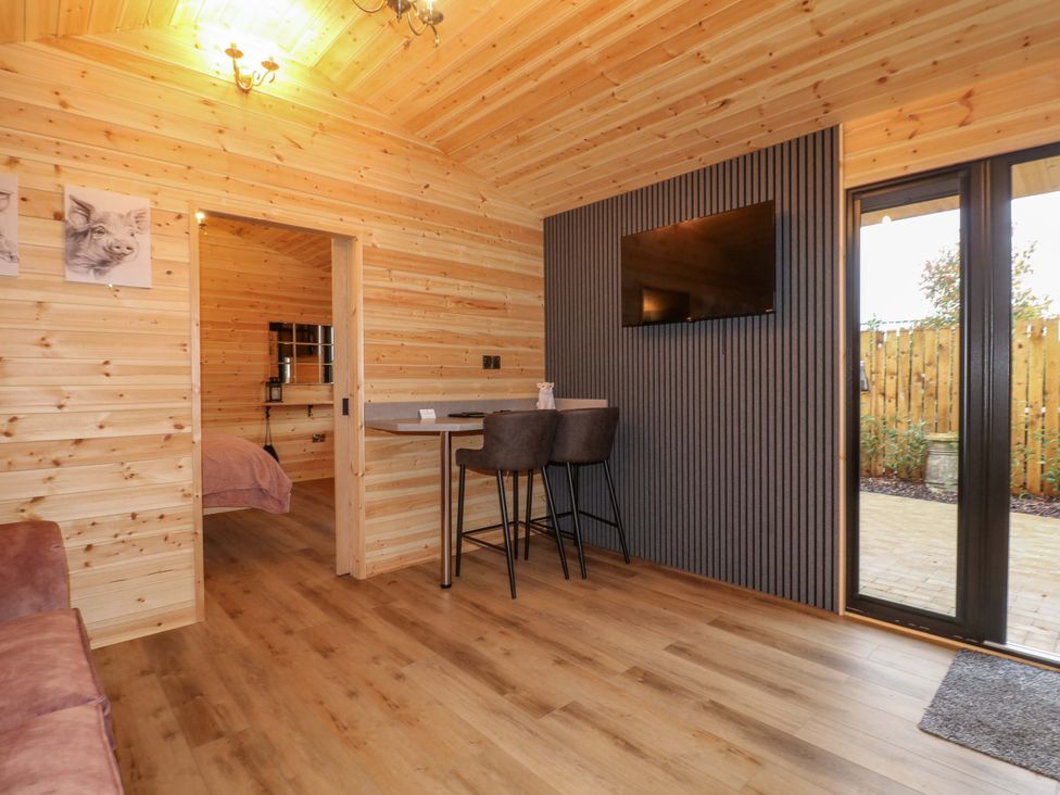 A living room with a bar table and stools at The Sty in Derby
