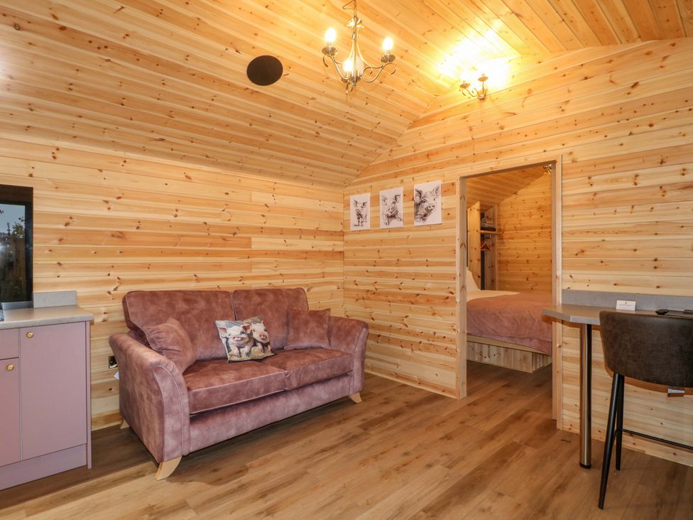 A living room with a purple sofa and door to a bedroom at The Sty in Derby