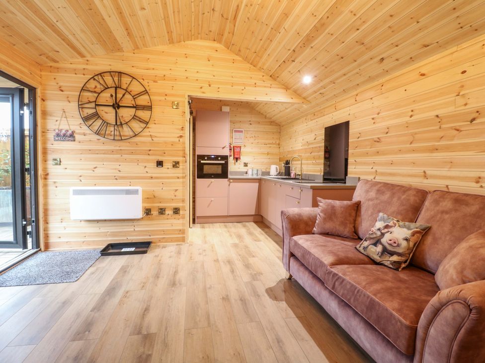 A living room with a sofa and kitchen area at The Sty in Derby
