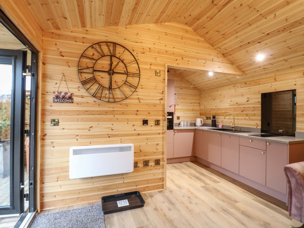A kitchen with wooden walls and a clock at The Sty in Derby