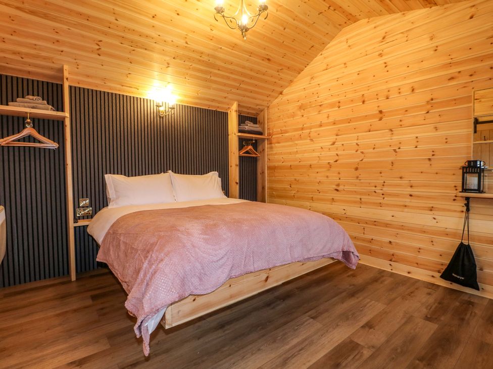 A bedroom with a wooden bed and shelves at The Sty in Derby