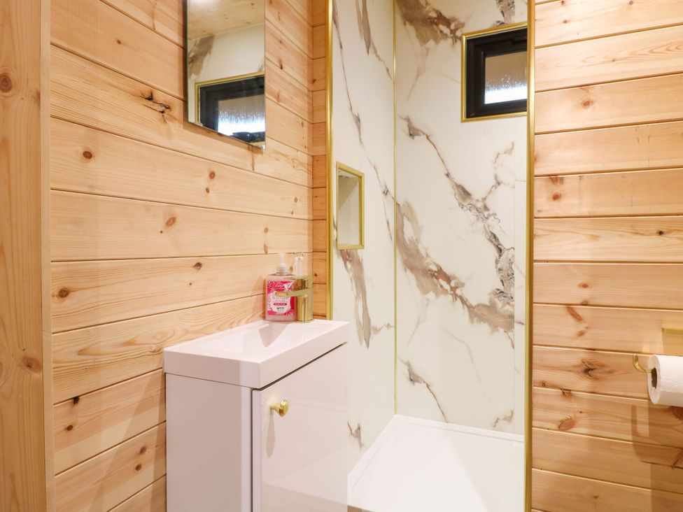 A bathroom with wooden walls and a sink at The Sty in Derby