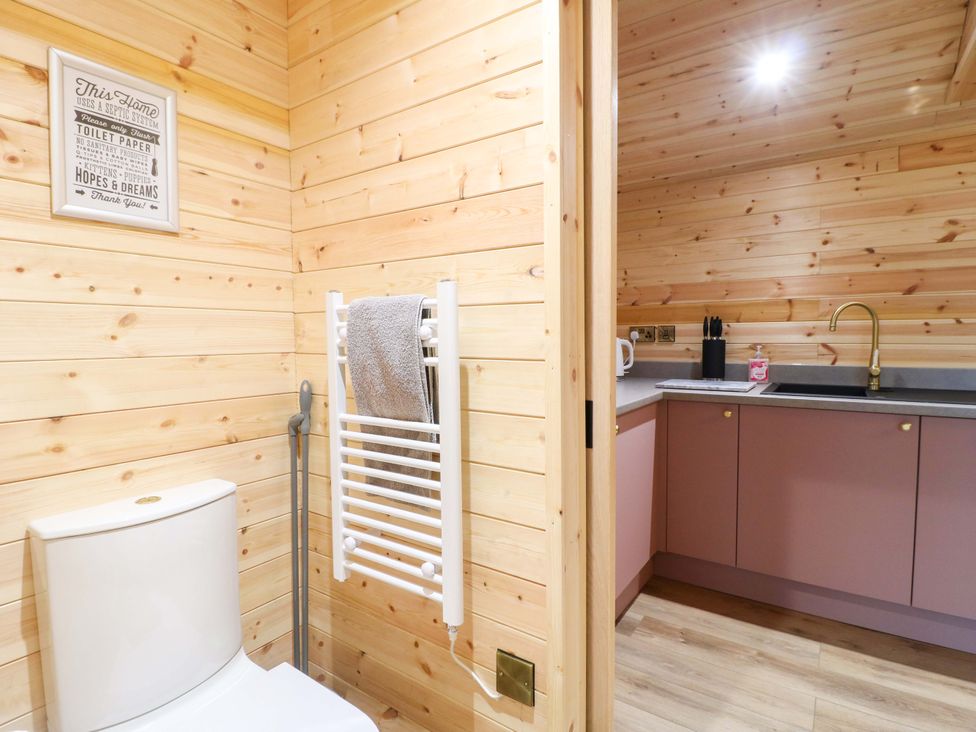 A bathroom with a toilet, towel rack, and kitchen counter at The Sty in Derby