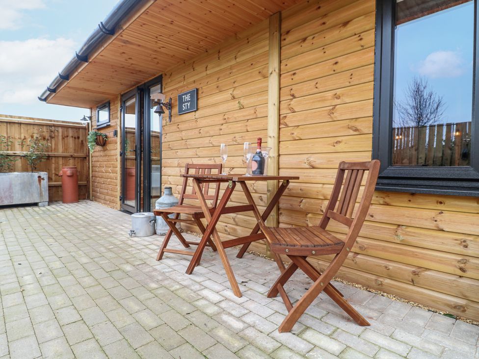 An outdoor seating area with table and chairs at The Sty in Hatton, Derbyshire