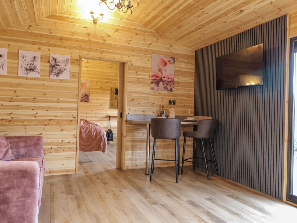 A living room with a sofa and bar stools at The Sty in Hatton, Derbyshire