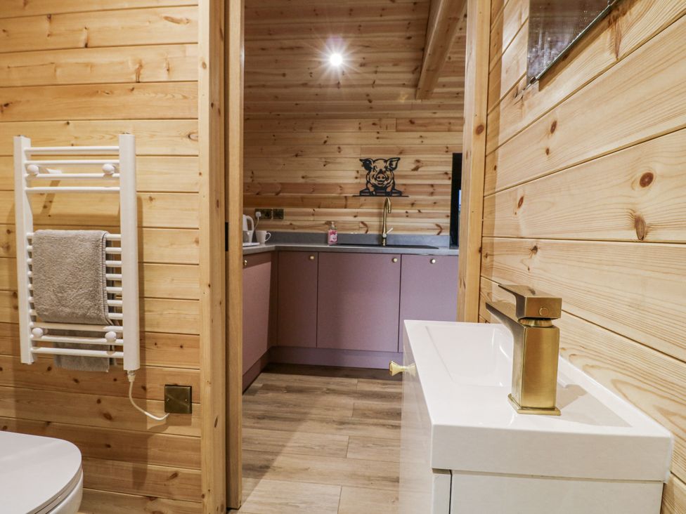 A bathroom with a towel radiator and sink at The Sty in Hatton, Derbyshire