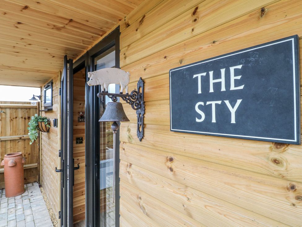 An entrance with a bell and sign at The Sty in Hatton, Derbyshire