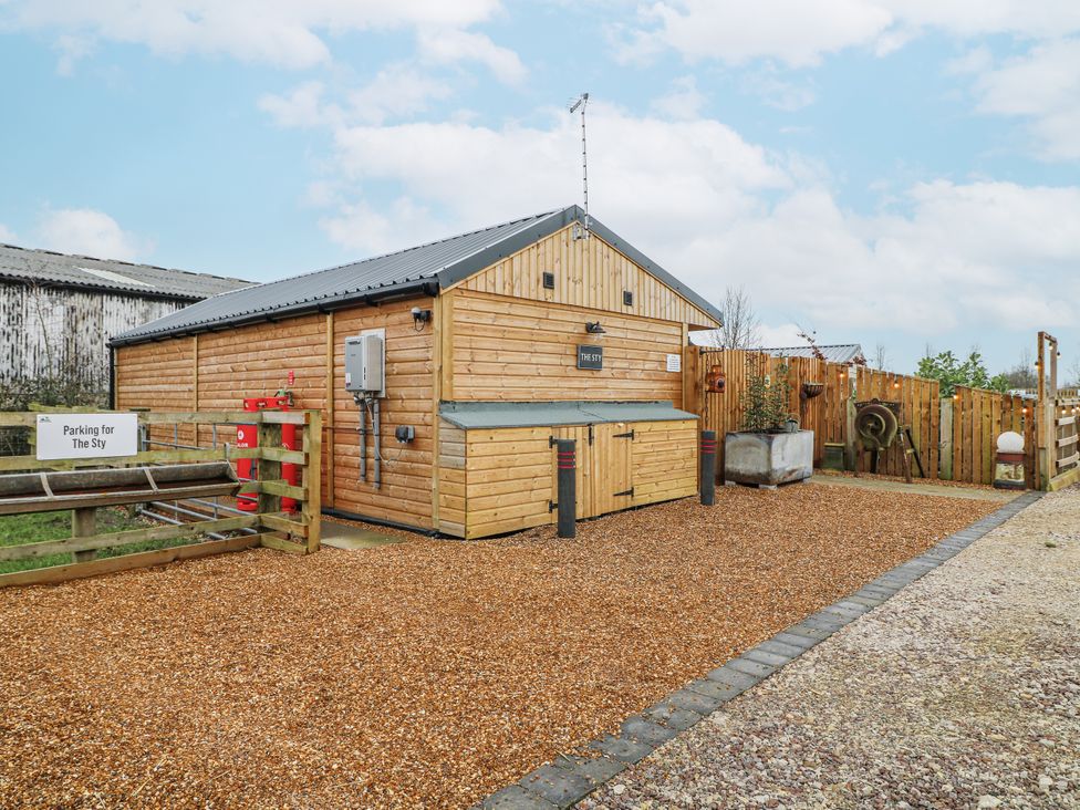 A wooden building with a parking area at The Sty in Hatton, Derbyshire
