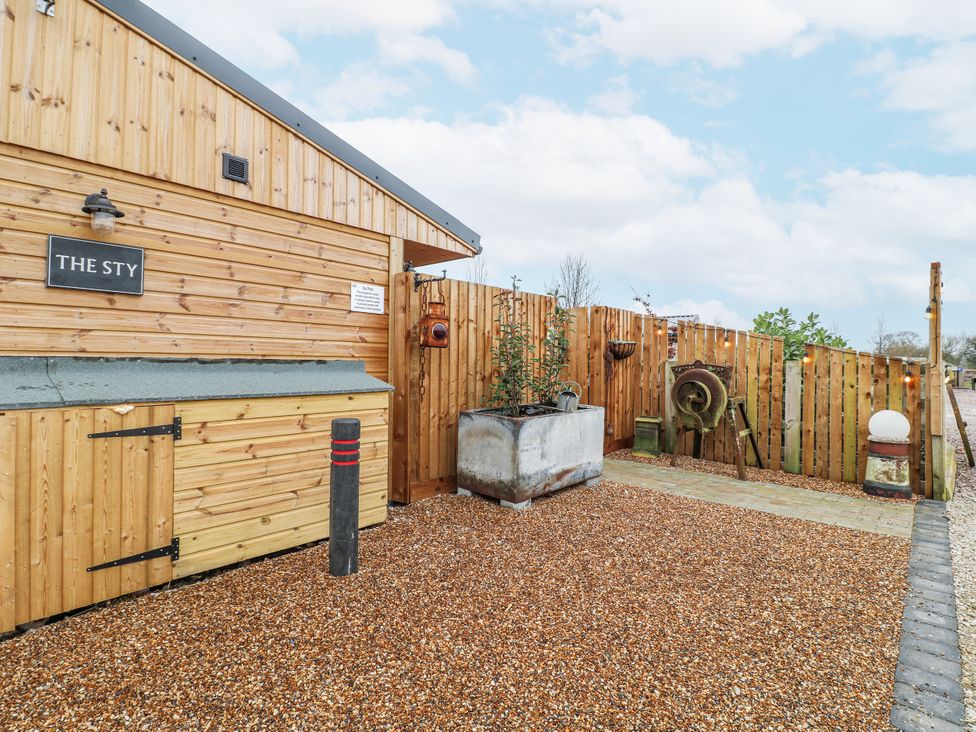 An outdoor area with a wooden cabin and gravel at The Sty in Hatton, Derbyshire