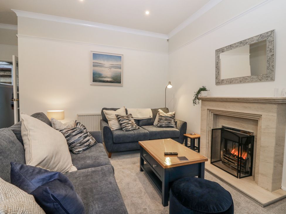 A living room with sofa and a fireplace at Cairndhu in Bossiney
