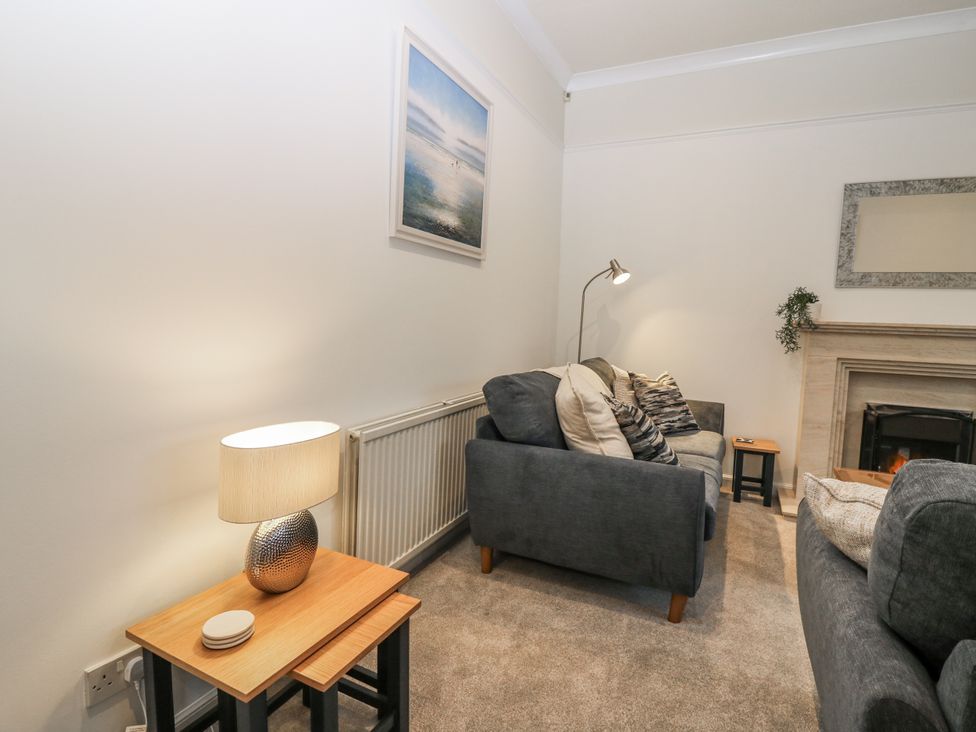 A living room with sofas and a lamp at Cairndhu in Bossiney