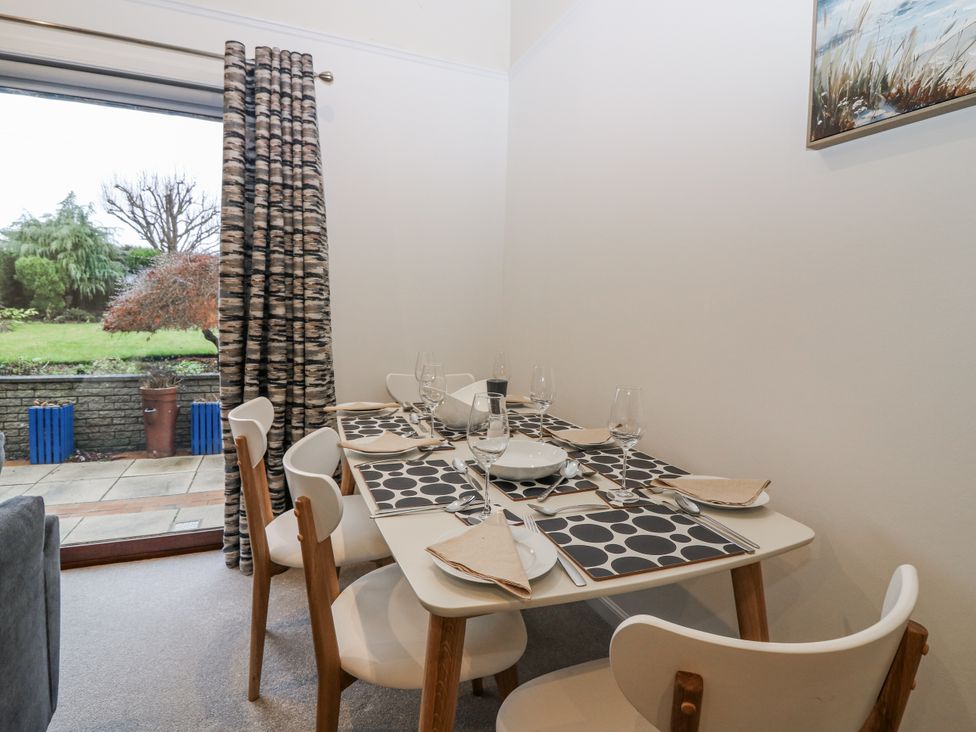 A dining room with a table set for meals at Cairndhu in Bossiney