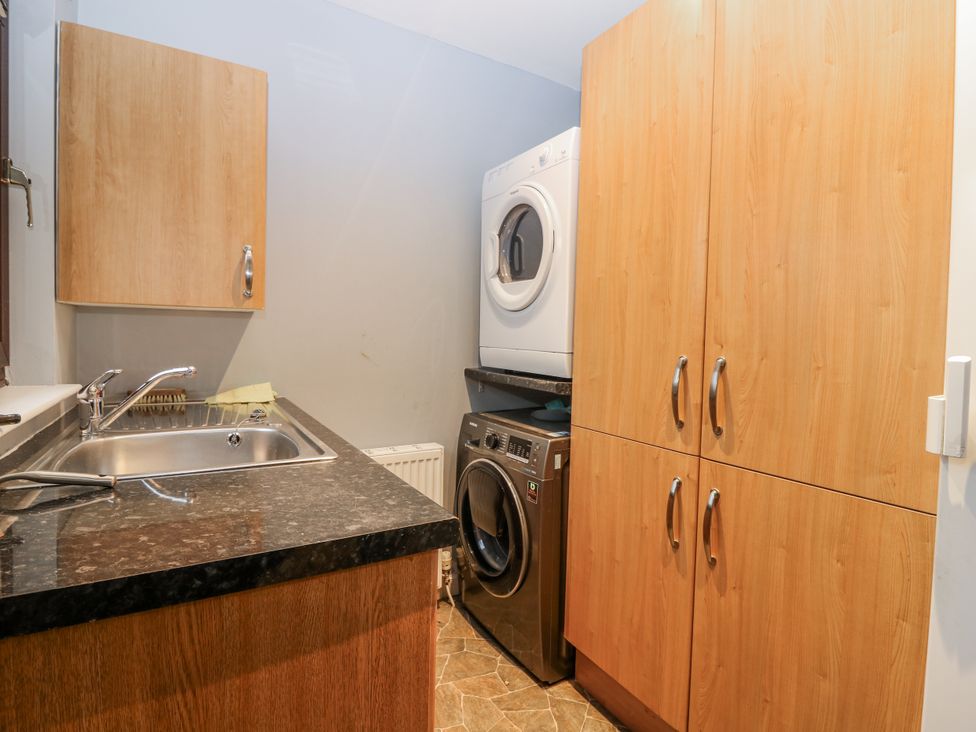 A laundry room with a sink and appliances at Cairndhu in Bossiney