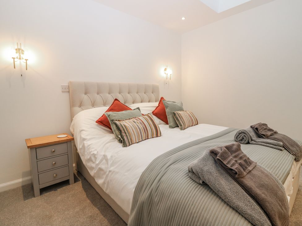 A bedroom with a bed and nightstand at Cairndhu in Bossiney