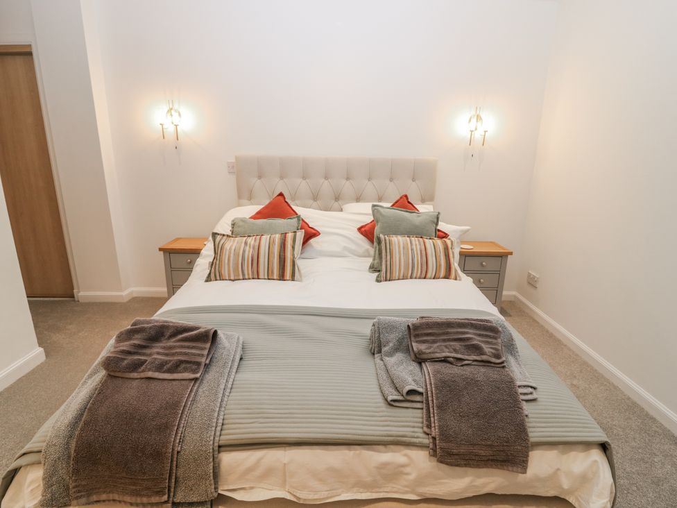 A bedroom with a bed and bedside table at Cairndhu in Bossiney