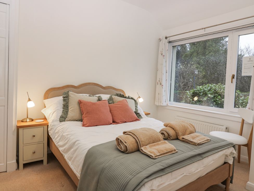 A bedroom with a bed and bedside table at Cairndhu in Bossiney