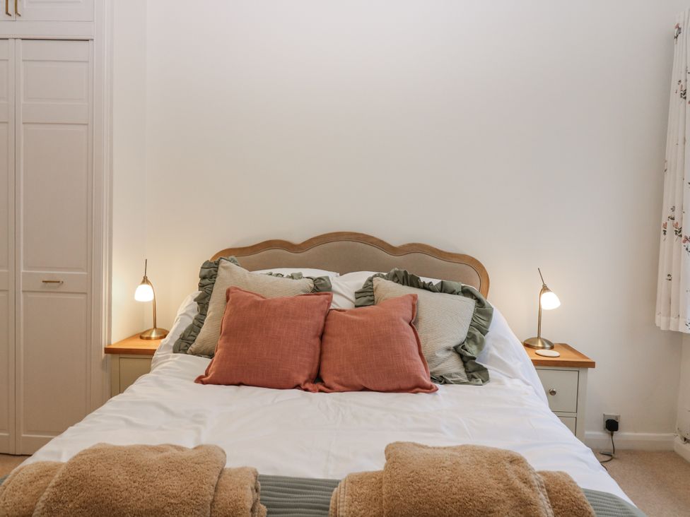 A bedroom with a bed and bedside lamps at Cairndhu in Bossiney