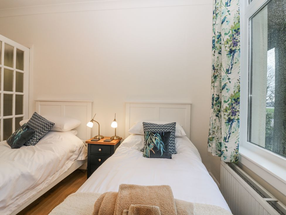 A bedroom with two beds and a window at Cairndhu in Bossiney