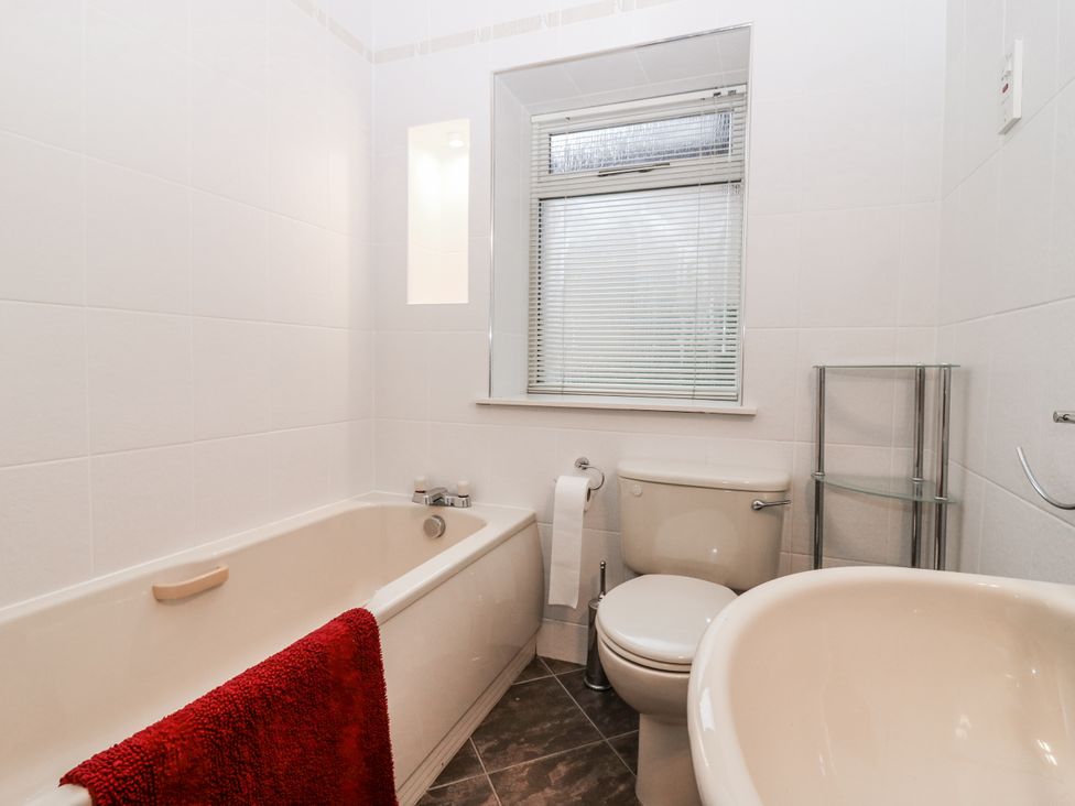 A bathroom with a bathtub and toilet at Cairndhu in Bossiney
