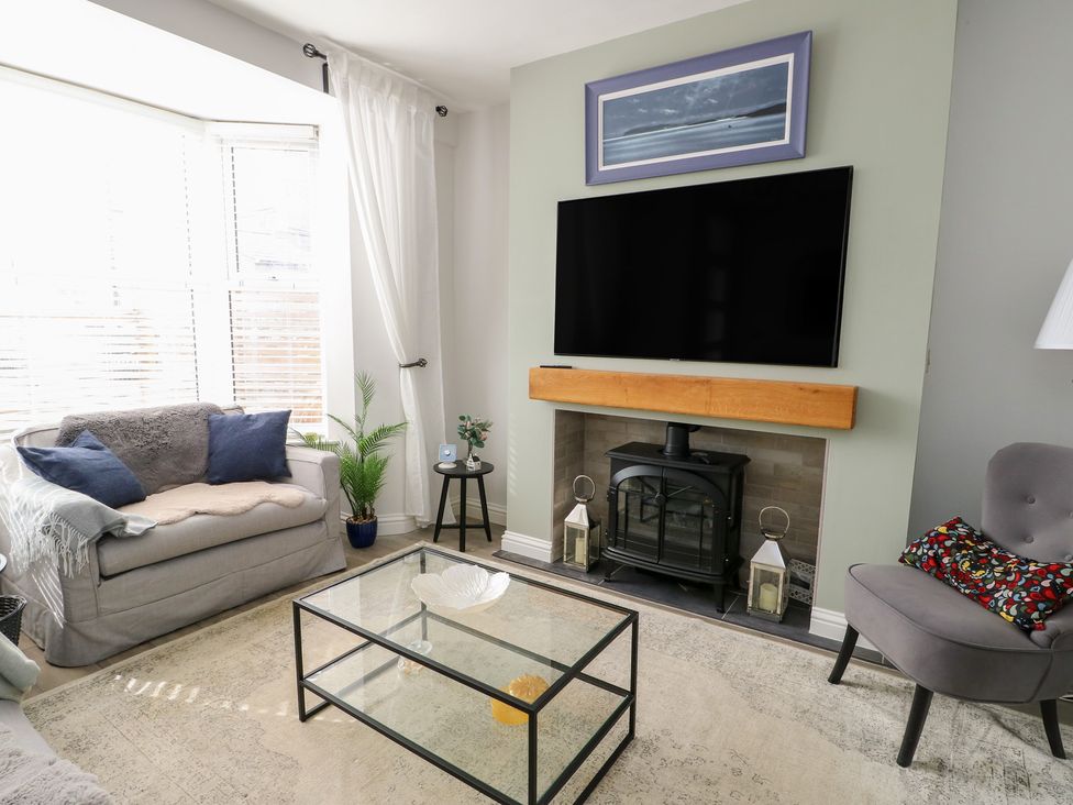 A living room with a sofa and a coffee table at Bryn Y Mor in Beaumaris