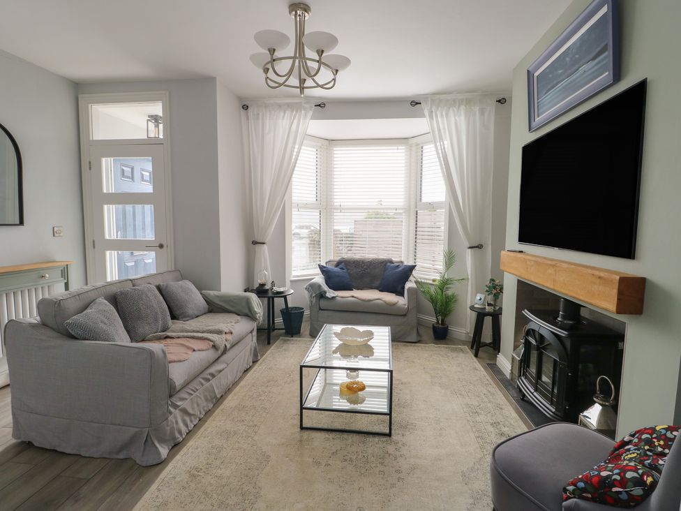 A living room with a sofa and coffee table at Bryn Y Mor in Beaumaris