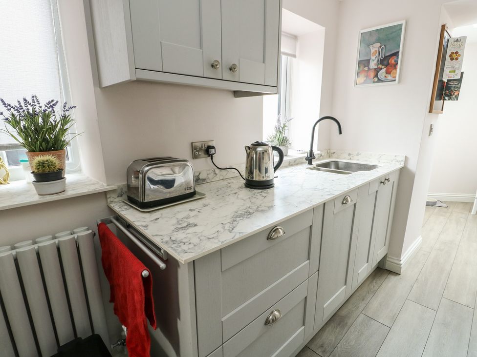 A kitchen with a kettle and toaster on the countertop at Bryn Y Mor in Beaumaris