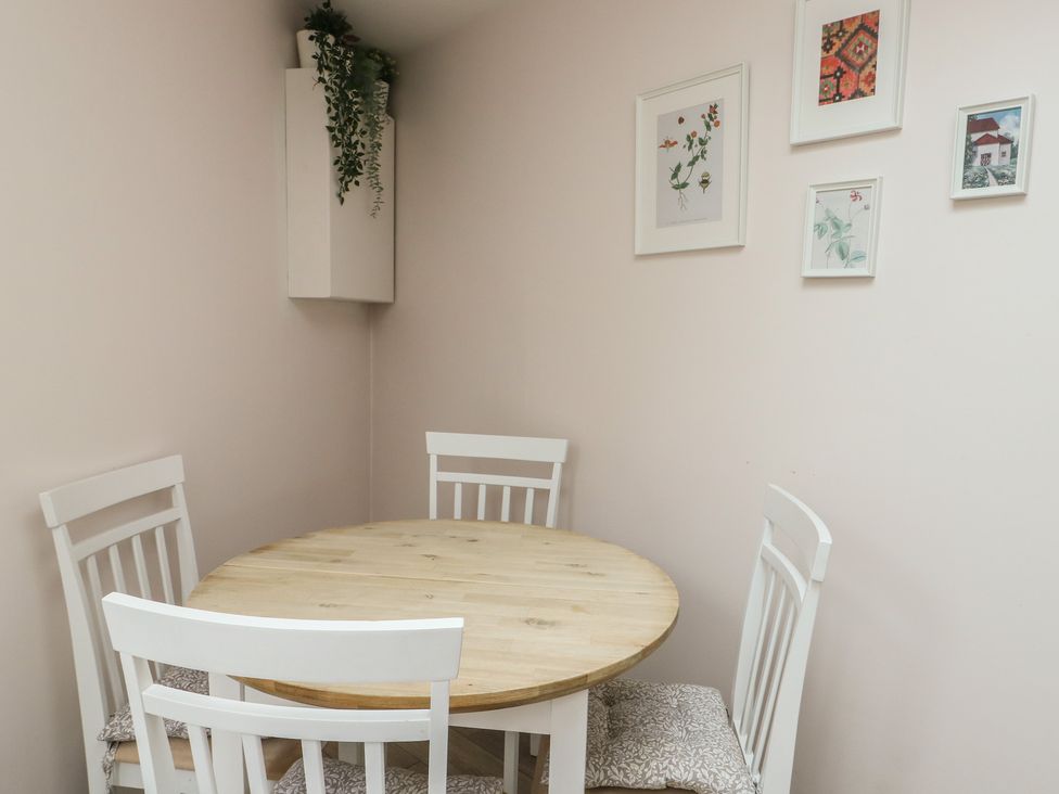 A dining room with a round table and four chairs at Bryn Y Mor Beaumaris