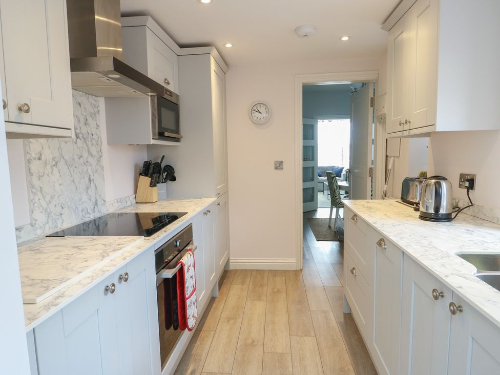 A kitchen with cabinets and appliances at Bryn Y Mor Beaumaris