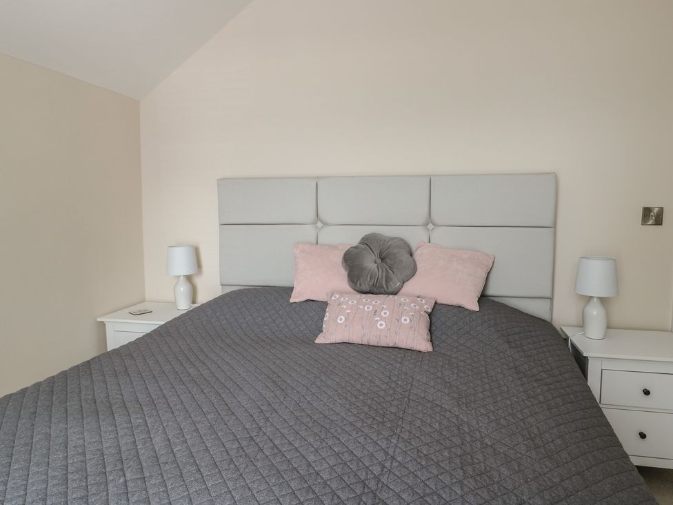 A bedroom with a bed and bedside tables at Bryn Y Mor Beaumaris