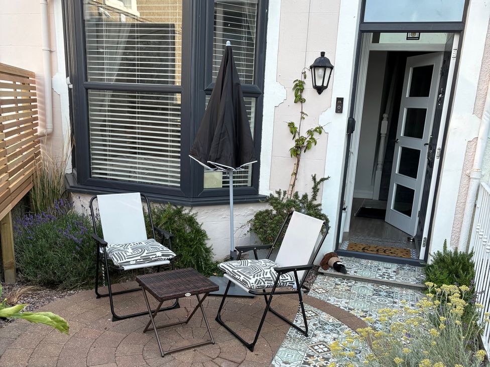 An outdoor seating area with chairs and a table at Bryn Y Mor in Beaumaris