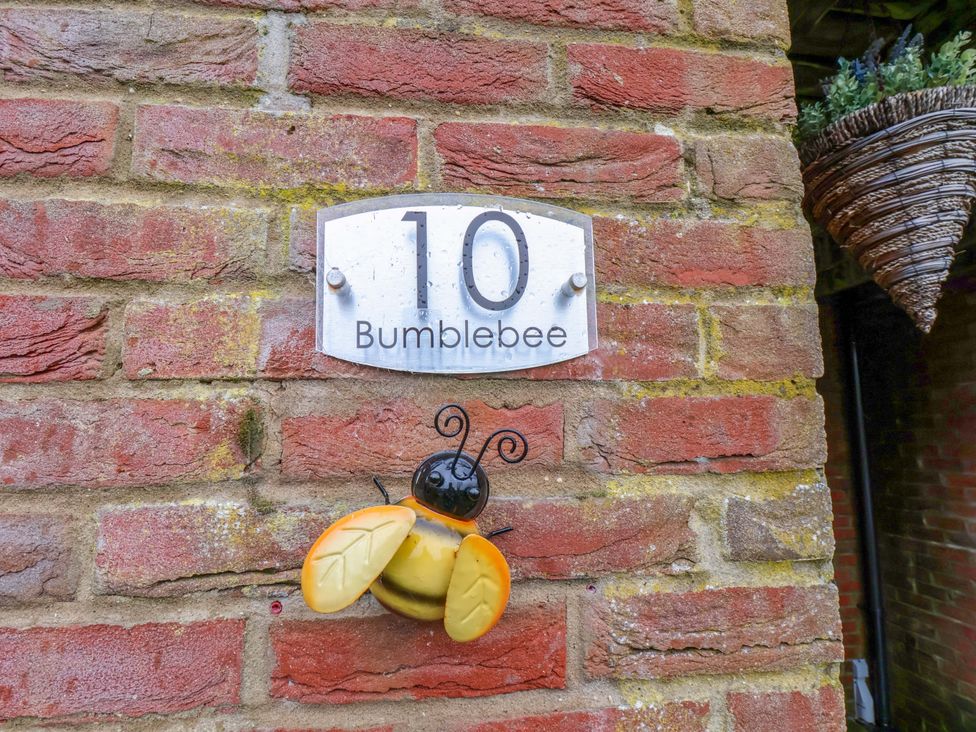 A house number sign and bee decoration at Bumblebee Cottage in Whitby