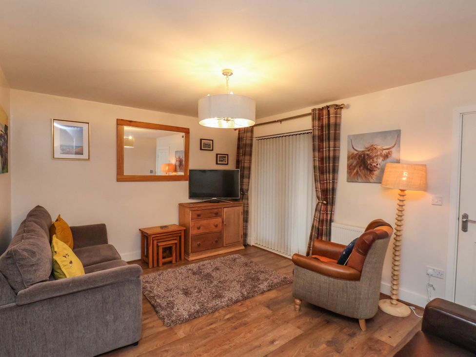 A living room with a sofa and television at Bumblebee Cottage in Whitby