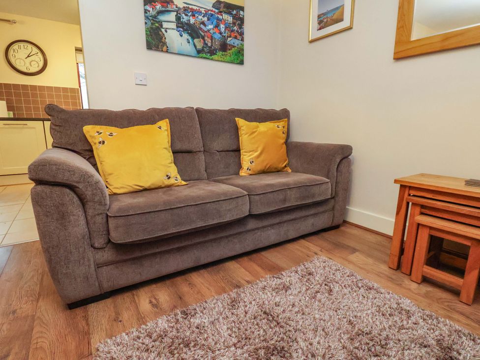 A living room with a sofa and side table at Bumblebee Cottage in Whitby
