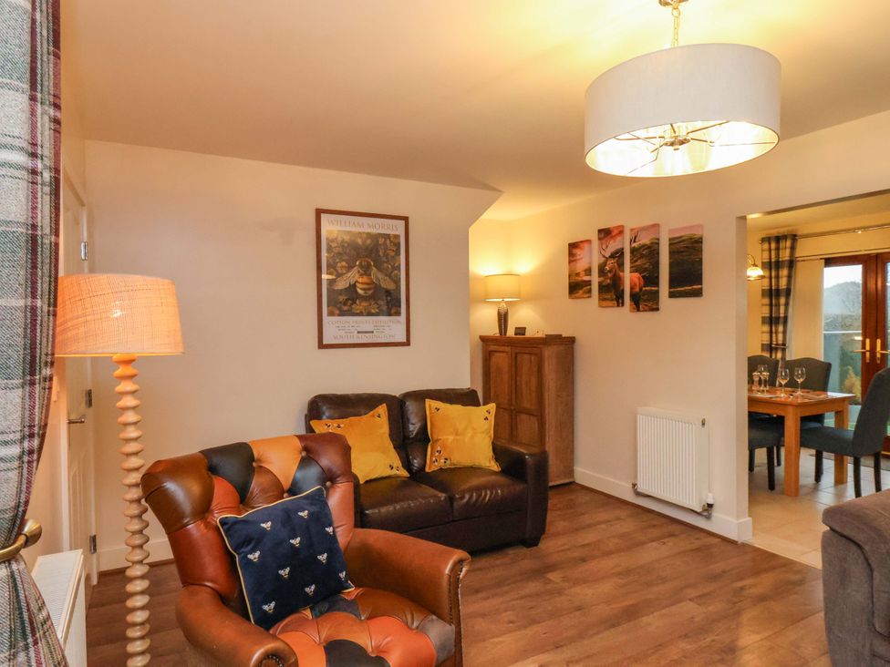 A living room with a sofa and dining area at Bumblebee Cottage in Whitby