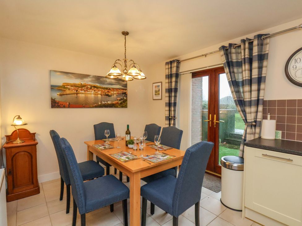 A dining room with table and chairs at Bumblebee Cottage in Whitby