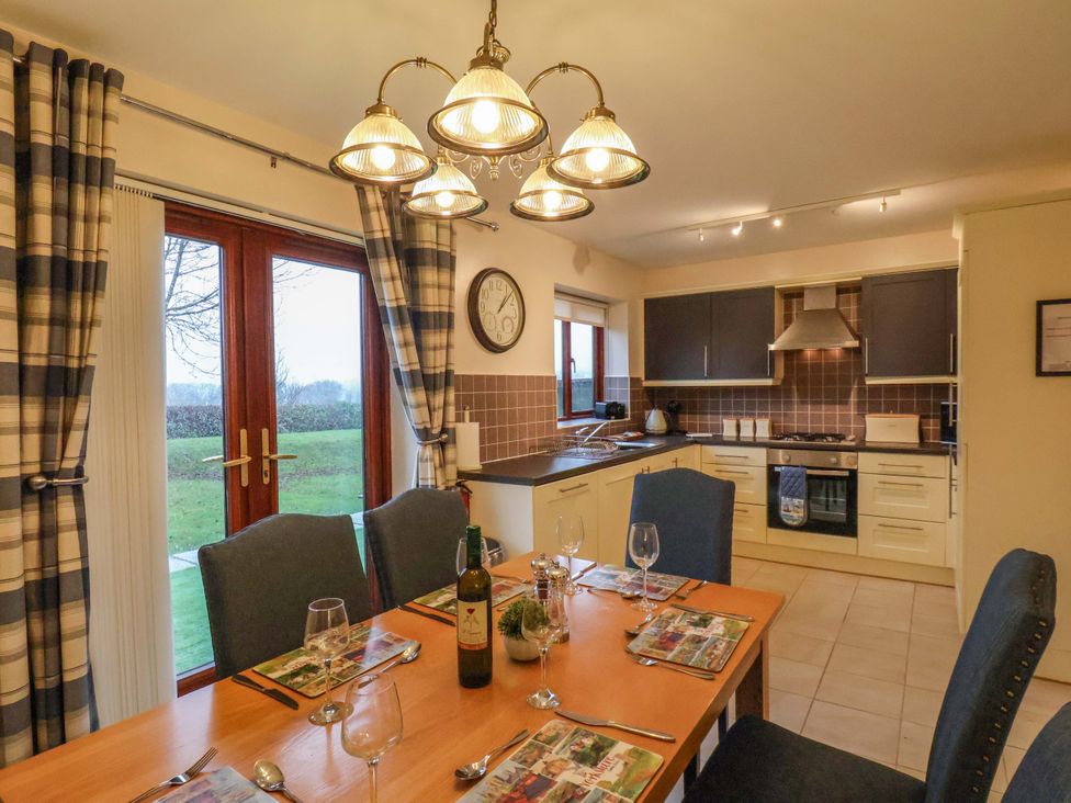 A kitchen with a dining table and chairs at Bumblebee Cottage in Whitby