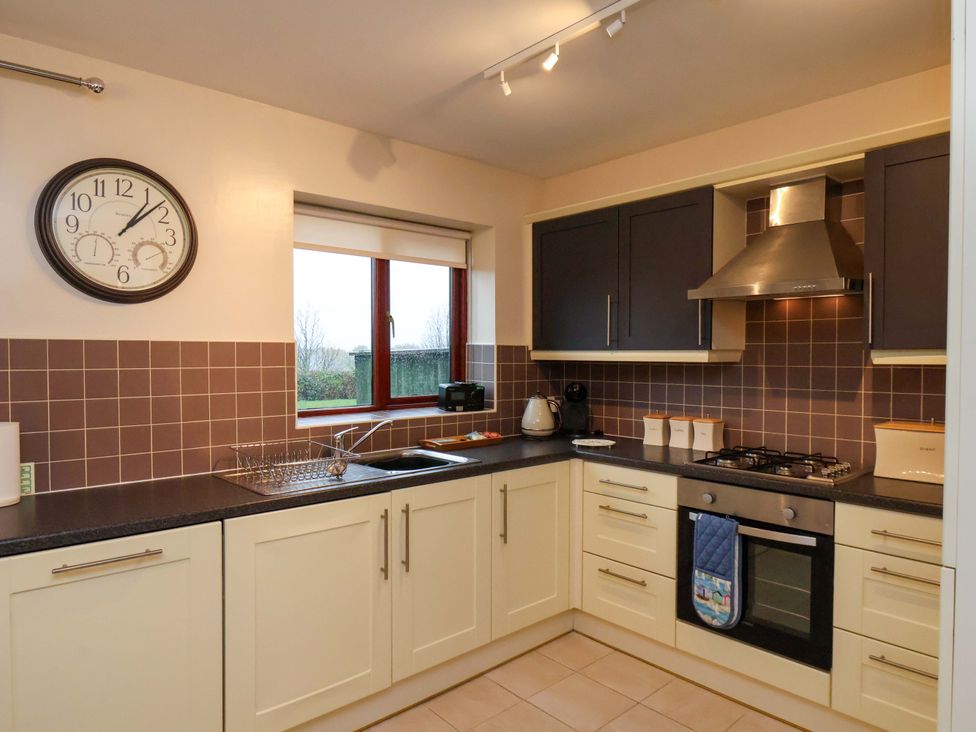 A kitchen with a window and appliances at Bumblebee Cottage in Whitby