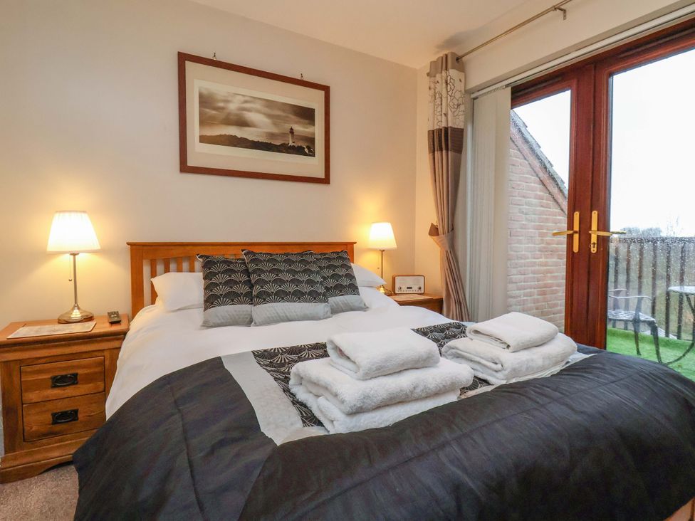 A bedroom with a bed and towels at Bumblebee Cottage in Whitby
