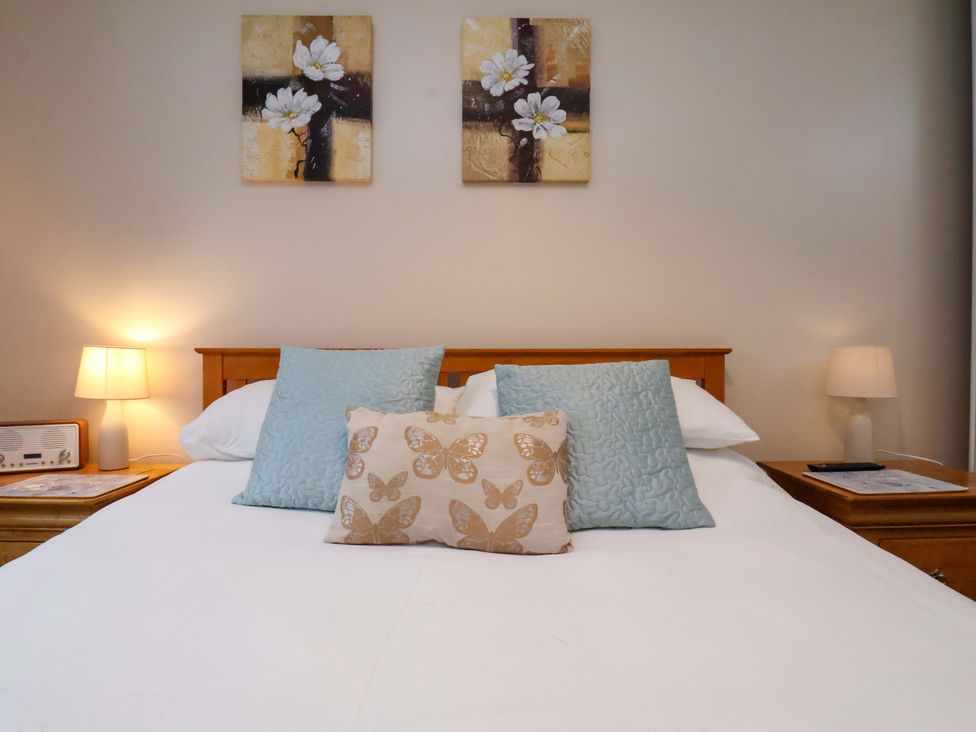 A bedroom with a bed and lamps at Bumblebee Cottage in Whitby