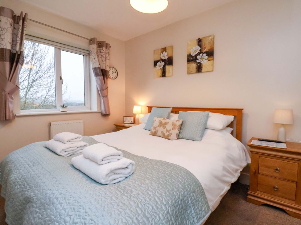 A bedroom with a double bed and window at Bumblebee Cottage in Whitby