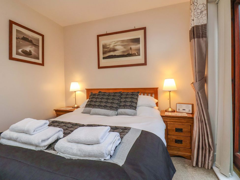A bedroom with a bed and bedside table at Bumblebee Cottage in Whitby