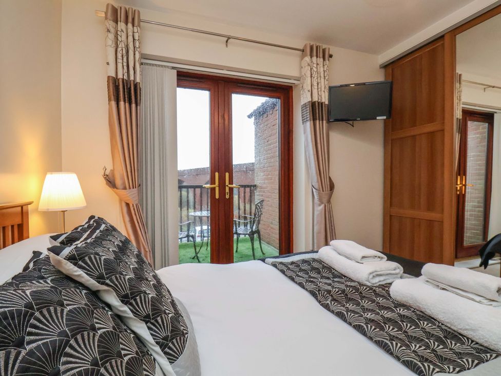 A bedroom with a bed and television at Bumblebee Cottage in Whitby