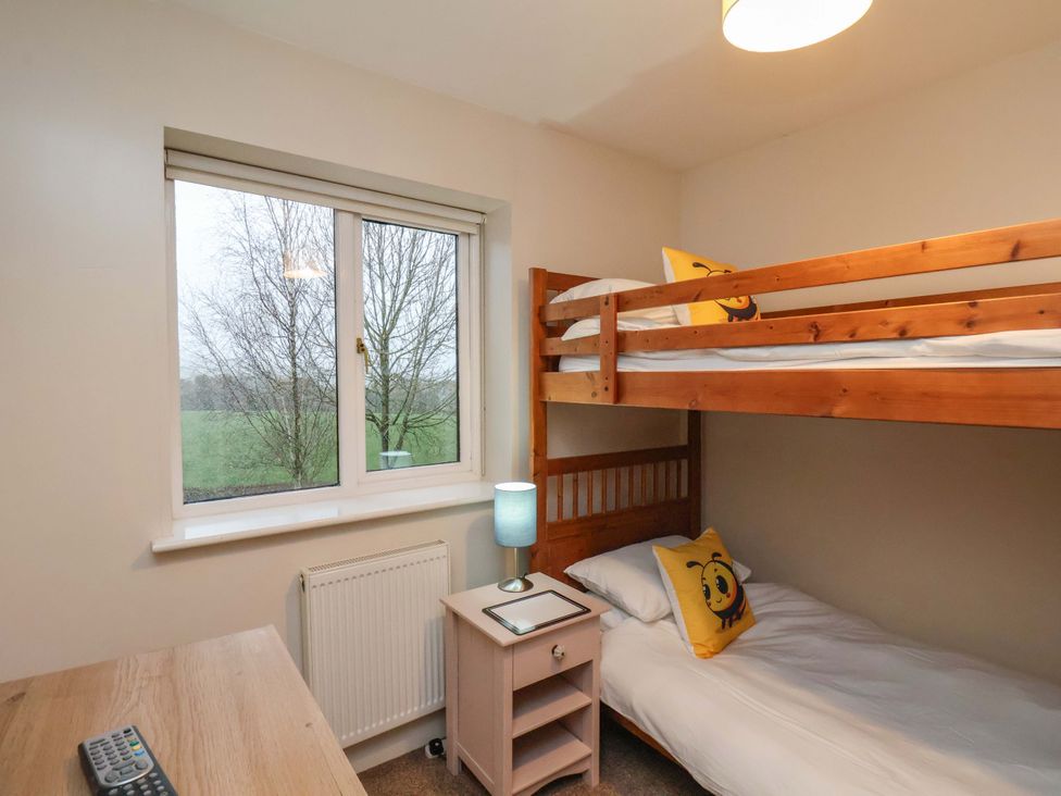 A bedroom with a bunk bed and single bed at Bumblebee Cottage in Whitby