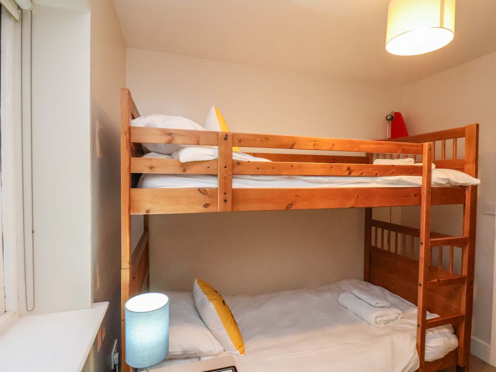 A bedroom with a bunk bed and a single bed at Bumblebee Cottage in Whitby