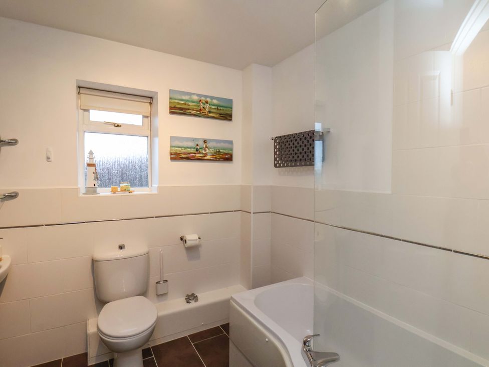 A bathroom with a shower and bathtub at Bumblebee Cottage in Whitby