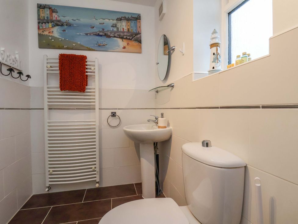 A bathroom with a sink, toilet, and towel radiator at Bumblebee Cottage in Whitby
