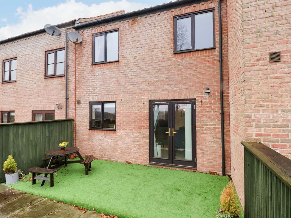 A garden area with a table and seating at Bumblebee Cottage in Whitby